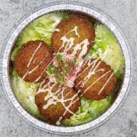 Falafel · Four pieces of falafel with lettuce and Tzatziki sauce and spices.