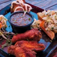 Sampler Platter · Two empanadas, three wings, two plantain lollipops, and fried yuca.