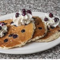 Blueberry Hotcakes · Full stack, bursting with blueberries and topped with whipped cream