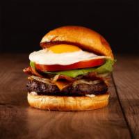 The Breakfast Burger · Beef patty, bacon, caramelized onions, melted cheddar cheese, mayo, and a fried egg on a bri...