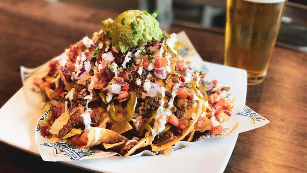 Rr Loaded Nachos · Crispy tortilla chips smothered with a house-made Russian River beer cheese, bacon, guacamole, tomato, red onion, honey-pickled jalapeno, sour cream, and cilantro.