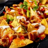 Ground Beef Super Nachos · Flavorful ground beef, refried beans, and onions topped with melted cheddar cheese and sour ...