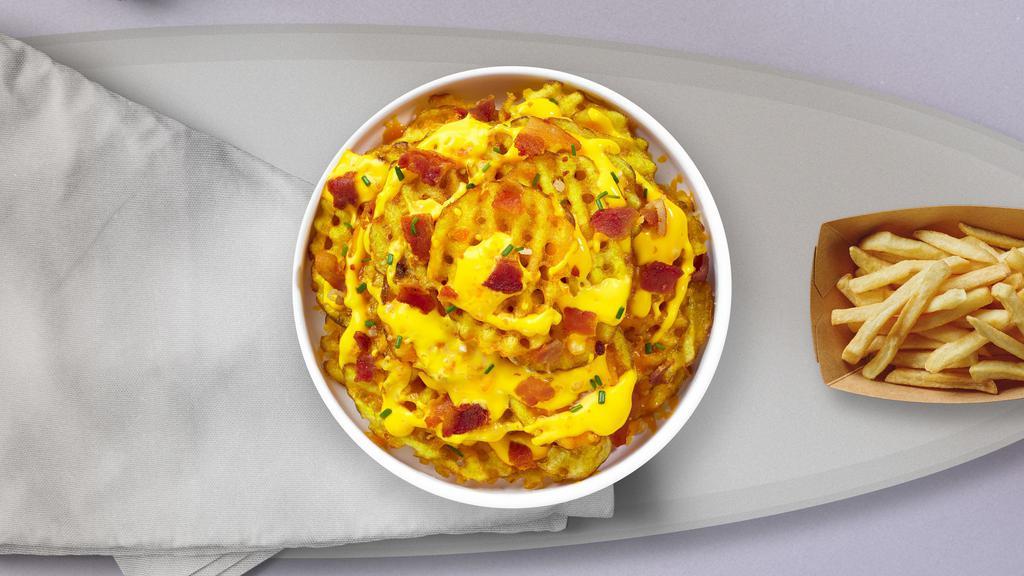 Full Load Waffle Fries · Idaho potatoes sliced criss-cut, fried until golden brown, and garnished with special cheese sauce, applewood smoked bacon, sour cream, chives, salt, and pepper