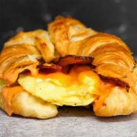 Croissant Bacon, Egg And Cheddar Sandwich · 2 scrambled eggs, melted Cheddar cheese, smoked bacon, and Sriracha aioli on a  warm croissant