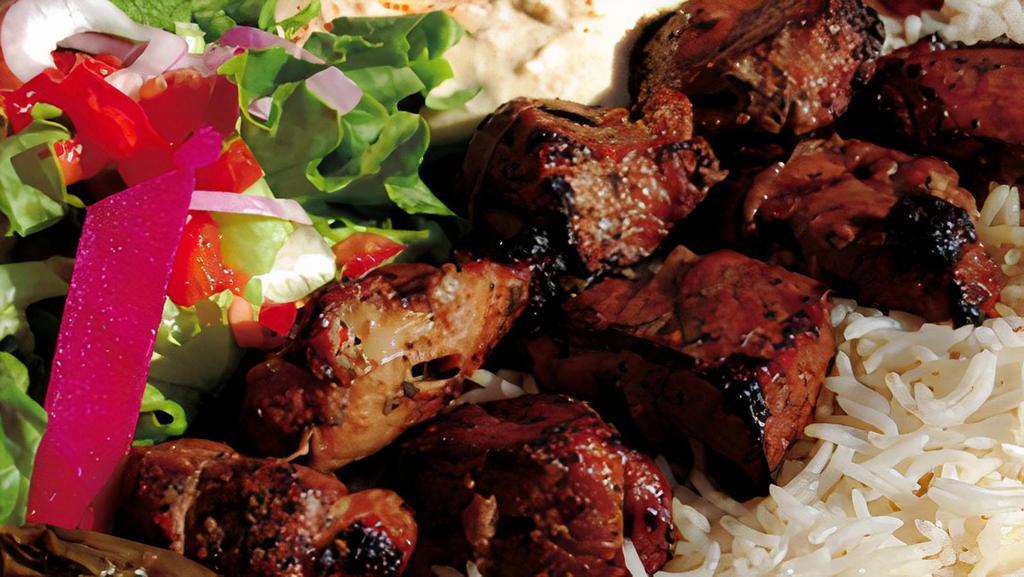 Beef Kabob · Marinated and char- grilled tender filet of beef, served with rice hummus salad and vegetables.