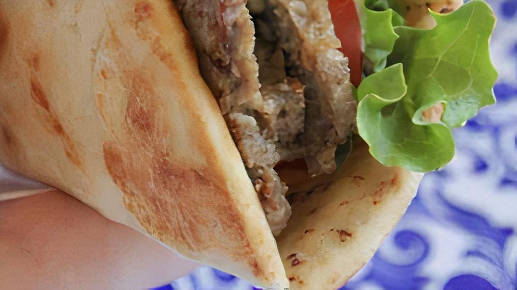 Beef Shawarma Wrap · Lean beef seasoned, sliced and marinated overnight, then served with tahini sauce, onions, lettuce tomato and pickles.