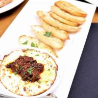 Baked Goat Cheese · topped with sun dried tomato pesto, served with a side of baked crostini