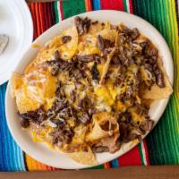 Nachos · Tortillas chips covered with jack & cheddar cheese, beans, ranchera sauce, pico de gallo & t...