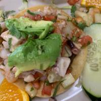 Tostada De Ceviche · Marinated in fresh lime juice & mixed with tomato, carrots, onion, cilantro, jalapeños & avo...