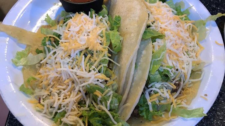 Tacos · With tostada chicken, seasoned ground beef or carnitas, served on red and white corn tortillas with lettuce, tomato, onion, olives, Cheddar cheese, sour cream, guacamole, and refried beans.