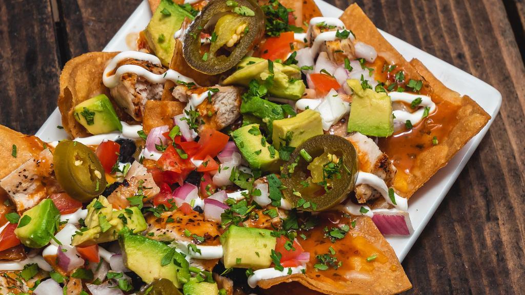 Grilled Chicken Nachos · Black beans / avocado / tomatoes / cilantro
red onions cheese blend / jalapeños
chipotle sauce / crema