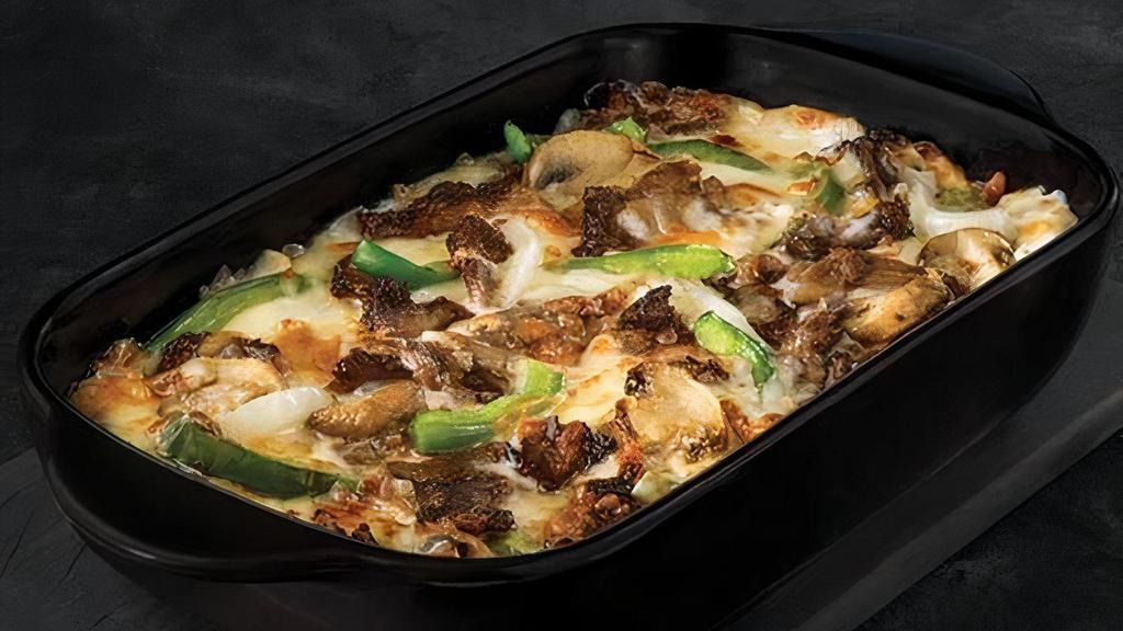 Philly Bowl · Crustless pizza baked in a bowl. Melty white cheese sauce, tender shaved steak, marinated mushrooms, freshly sliced green peppers, onions, and our three fresh signature cheeses.