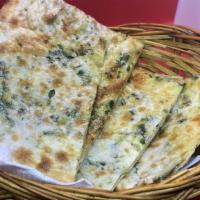 Cheese And Spinach Naan · Tandoor oven baked flatbread with cheese and spinach.
