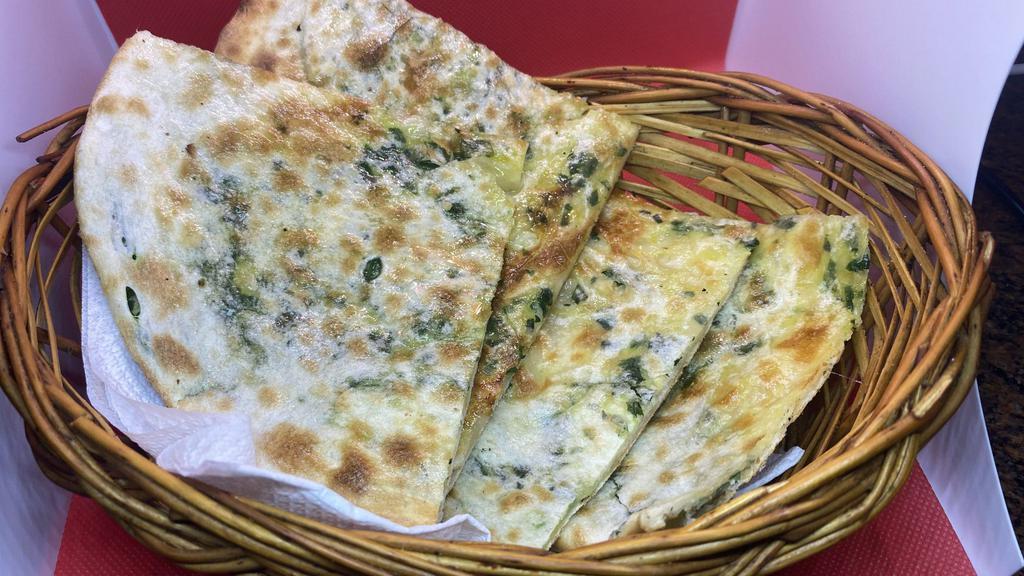 Cheese And Spinach Naan · Tandoor oven baked flatbread with cheese and spinach.