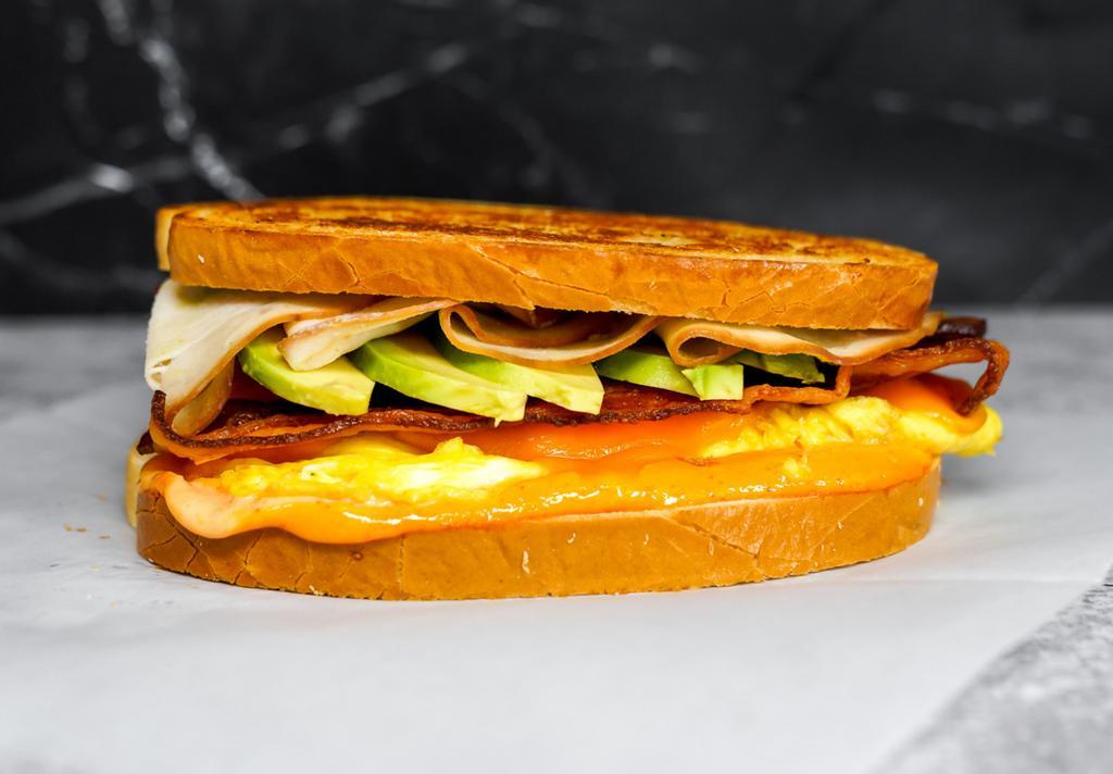 Sourdough, Bacon, Turkey, Avocado, Egg, & Cheddar Sandwich via