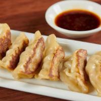 Pork Gyoza. · Pan-fried pork dumplings served with gyoza sauce.