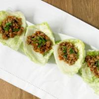 Chicken Lettuce Wraps · Ground chicken with water chestnuts, carrots, garlic topped with green onions. Served on gre...