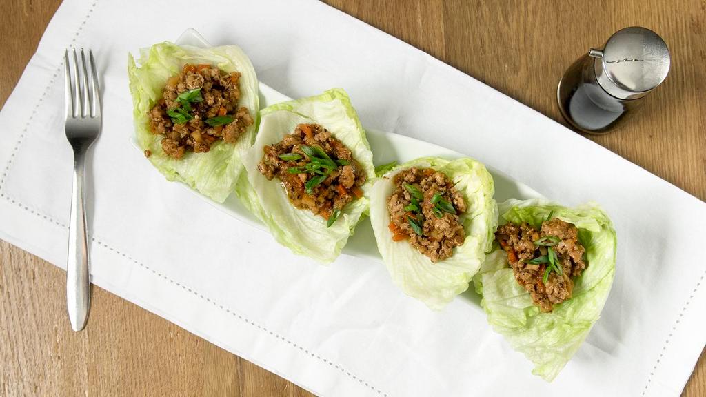 Chicken Lettuce Wraps · Ground chicken with water chestnuts, carrots, garlic topped with green onions. Served on green leaf lettuce. Four pieces.