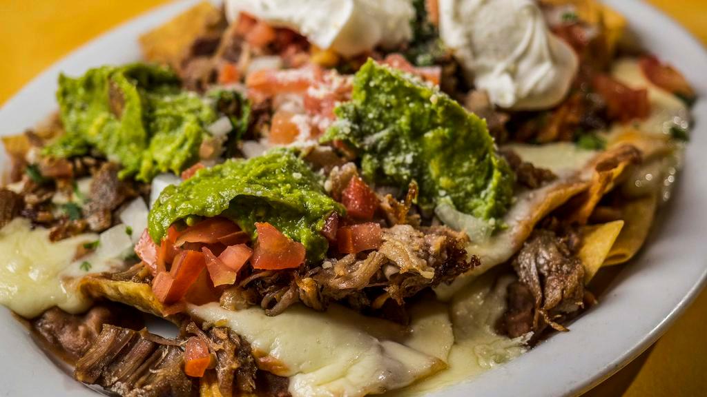 Super Nachos (No Meat) · Corn tortilla chips, loaded with Jack cheese, beans, enchilada sauce, salsa fresca, guacamole and sour cream.