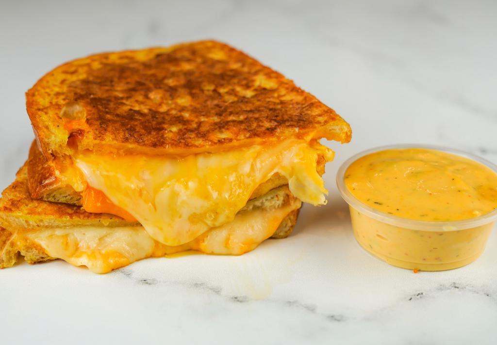 Three Cheese Monte Cristo · Cheddar, Swiss, and Parmesan cheeses melted between egg dipped, griddled sourdough bread. Served with a side of Spicy Honey Mustard Aioli.