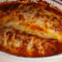 Manicotti Al Forno · Homemade noodles wrapped around a filling of three cheeses, topped with tomato sauce and two...