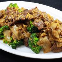 Phad See Ew · Flat rice noodles stir fried in black soy sauce with broccoli and egg.