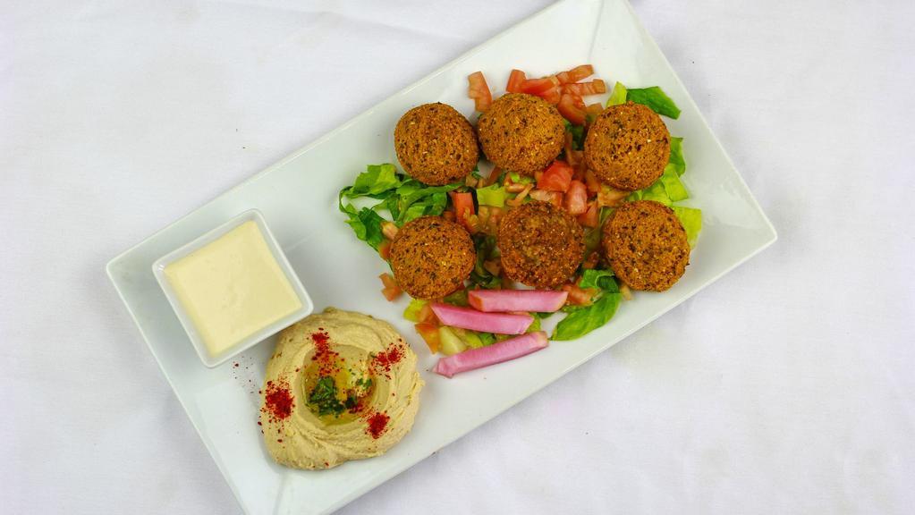 Falafel Plate · Pieces of fresh falafel, served with hummus, tahini, pickles, lettuce, and tomato.