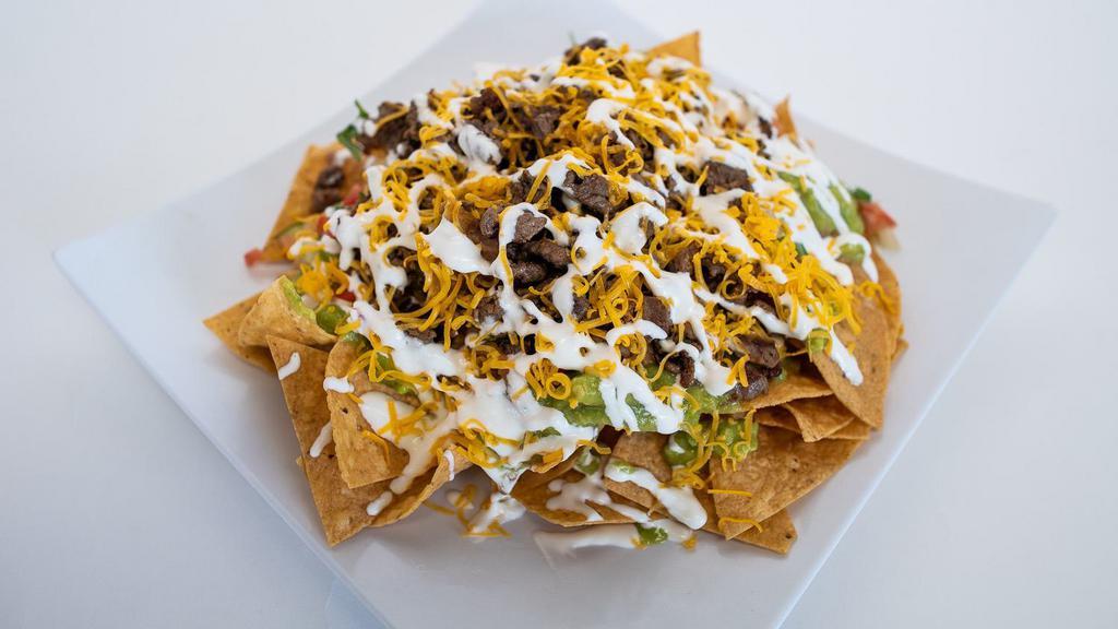 Nachos W/ Choice Of Meat · Choice of Meat, Our Tortilla Chips, Beans, Pico de Gallo, Sour Cream, Guacamole, and Cheese.