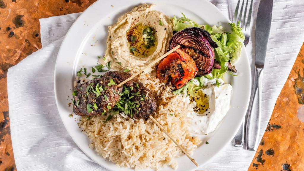 Kefta Kabob · Ground spiced beef and lamb skewers. Grilled and served with rice, lebne, hummus, tomato, and onion.