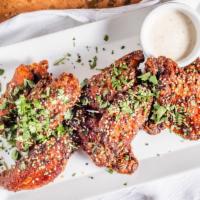 Harissa Chili Chicken Wings · Topped with sesame seeds and garlic aioli.