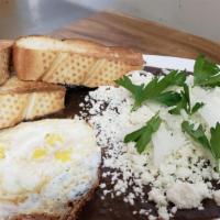 Enfrijoladas Con Huevo · Four com tortillas dipped in a black bean sauce, with two eggs, queso fresco, onion and pars...