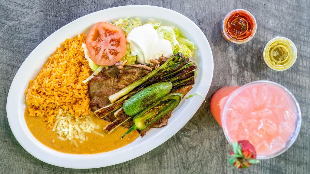 Carne Asada Plate · Two slices of thin steak with green onions, grilled jalapeÃ±os. Served with rice and beans, cheese, sour cream, guacamole, lettuce, pico de gallo, tortillas.