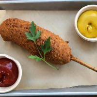 Happy The Corndog · A vegan hotdog in a nutrition-pumped hempseed-cornmeal batter and fried on a stick. All Vegan.