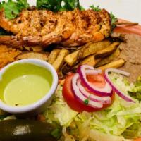 Camarones A La Plancha · Grilled jumbo shrimp served with rice, beans, salad, French fries, and guacamole.