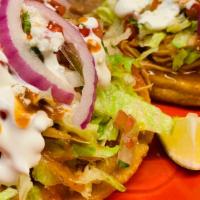 Sope · Thick tortilla topped with beans, meat, lettuce, sour cream, and choice of meat.