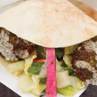 Falafel Sandwich · Four falafel balls, one topping, mixed green salad and tahini dressing.