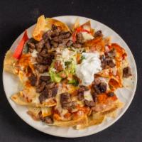 Nachos · Chips in a bed of refried beans and topped with pinto beans, melted cheese, pico De gallo (o...