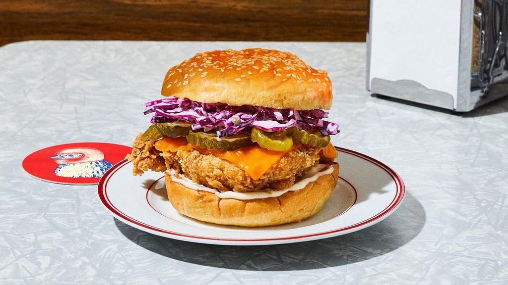The Og With Cheese Fried Chicken Sandwich · Our signature fried chicken served on a toasted bun and topped with coleslaw, cheddar cheese, pickles, and mayonnaise.