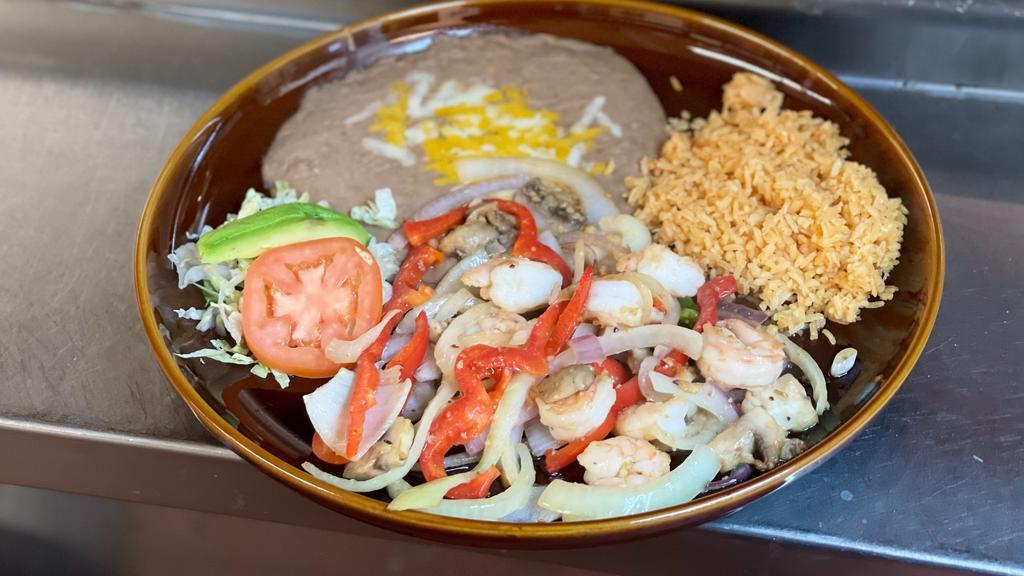 Camarones Al Mojo De Ajo · Grilled shrimp cooked in garlic sauce. Served with lettuce, tomatoes, guacamole salad, rice, beans and tortillas.