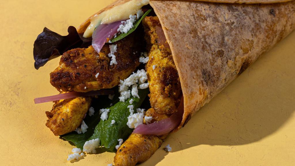 Chicken Shawarma Wrap · The Chicken Shawarma Wrap comes with, garlic hummus, spring mix, made in-house chicken shawarma, pickled onion and feta cheese wrapped in a warm sundried tomato tortilla.