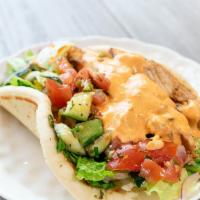 Spicy Grilled Chicken Pita · Grilled chicken, fire feta sauce, lettuce, and cucumber tomato salad on warm pita.