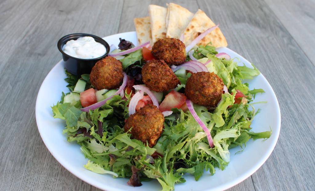 Falafel Salad · Vegan. Spring mixed greens tossed with lemon tahini dressing, topped with chickpea falafel, pickled onions, cucumbers and tomatoes.