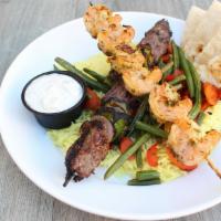 Surf & Turf Plate · Grilled shrimp skewer and steak skewer served on a bed of seasoned basmati rice with roasted...