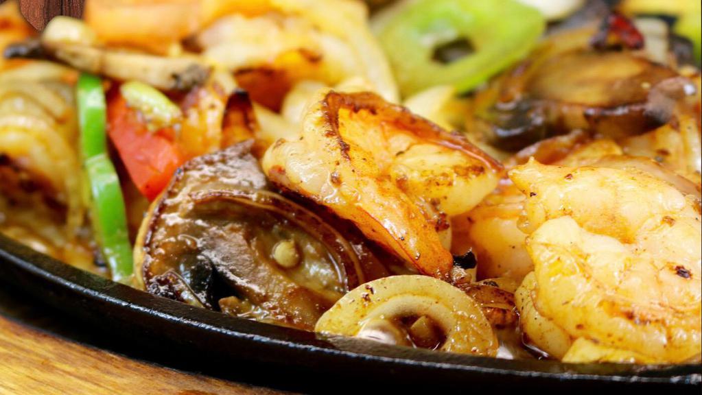 Fajitas De Camaron · Shrimp grilled in butter with onions bell peppers, tomatoes, and mushroom.