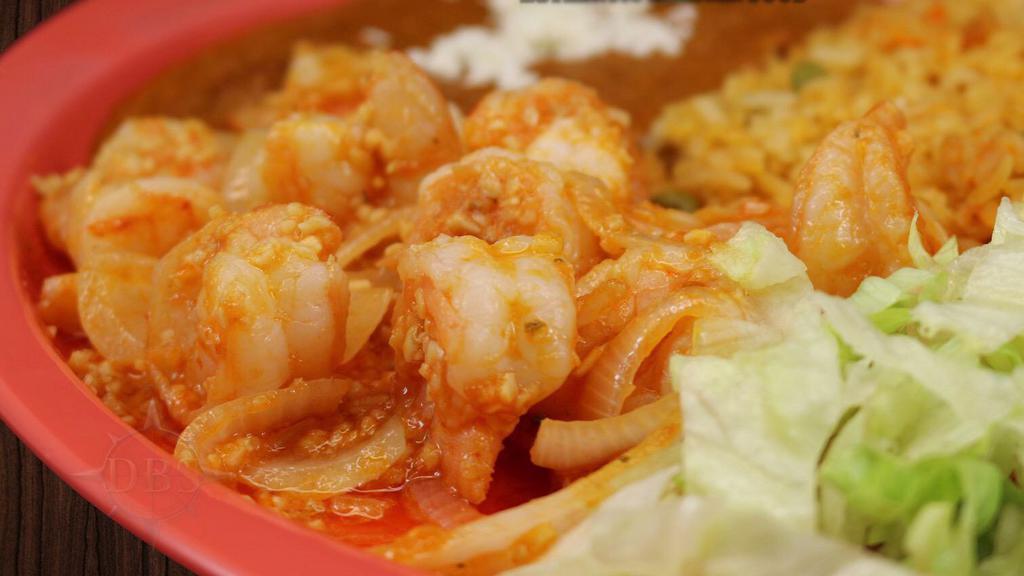 Camarones Al Mojo De Ajo · Shrimp in butter with garlic and onions and red sauce.