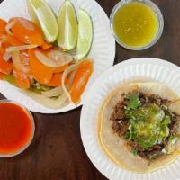 Taco Cabeza · Beef cheek, corn tortilla, onions, cilantro, and green salsa.