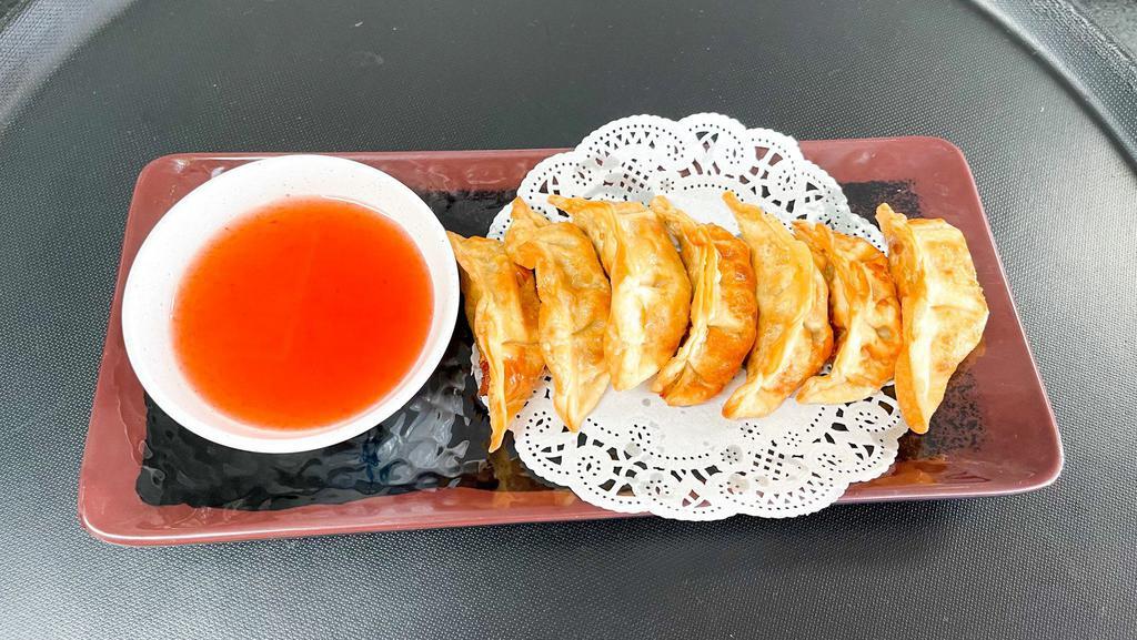Fried Chicken Gyoza · Fried dumplings with marinated chicken served with sweet and sour sauce.