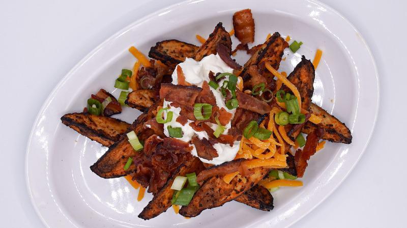 Loaded Potato Wedges · Roasted Potato Wedges topped with Cheddar Cheese, Smoked Bacon Crumbles, Sour Cream, and Green Onion. Served with your choice of dressing for dipping