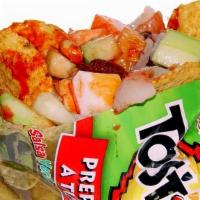 Tostilocos · Totitos chips topped with cucumber, jicama, mango, japanese peanuts, lime, chili sauce, cham...