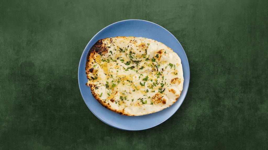 Garlic Naan · Refined wheat leavened flatbread, baked in a clay tandoor till crisp outside, and topped with garlic.